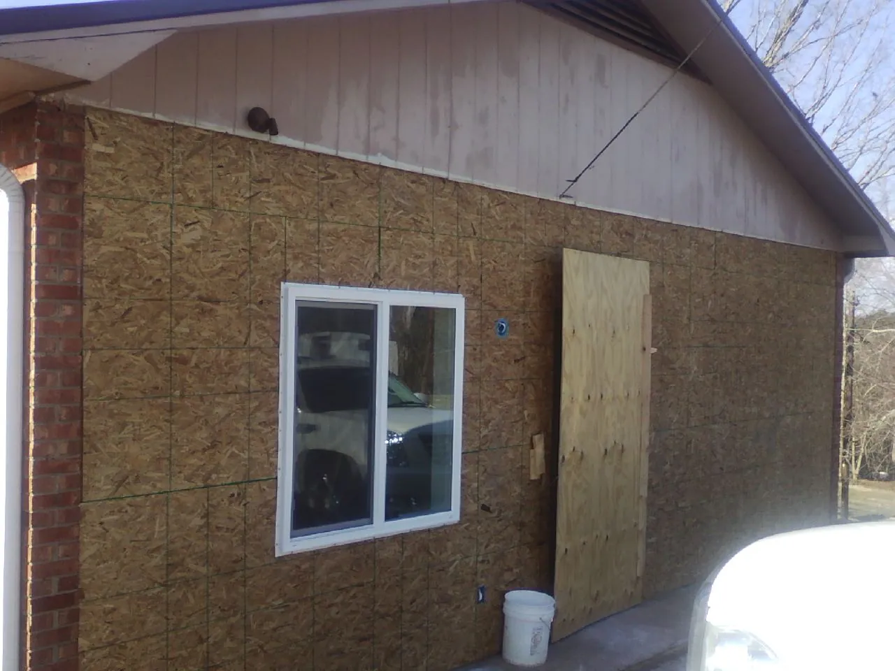 OSB sheathing on a garage addition wall before siding in Mulliken
