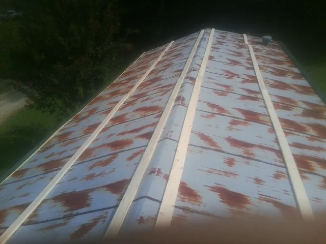 Rusted metal roof panels with new wood purlins before replacement — Storm Damage Roof Repair in Mulliken by Roofing Brothers